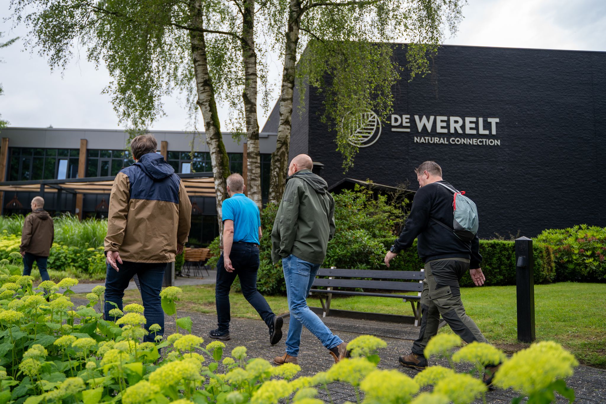 Deelnemers lopen door de groene omgeving van De Werelt Lunteren tijdens een meerdaags congres op de Veluwe