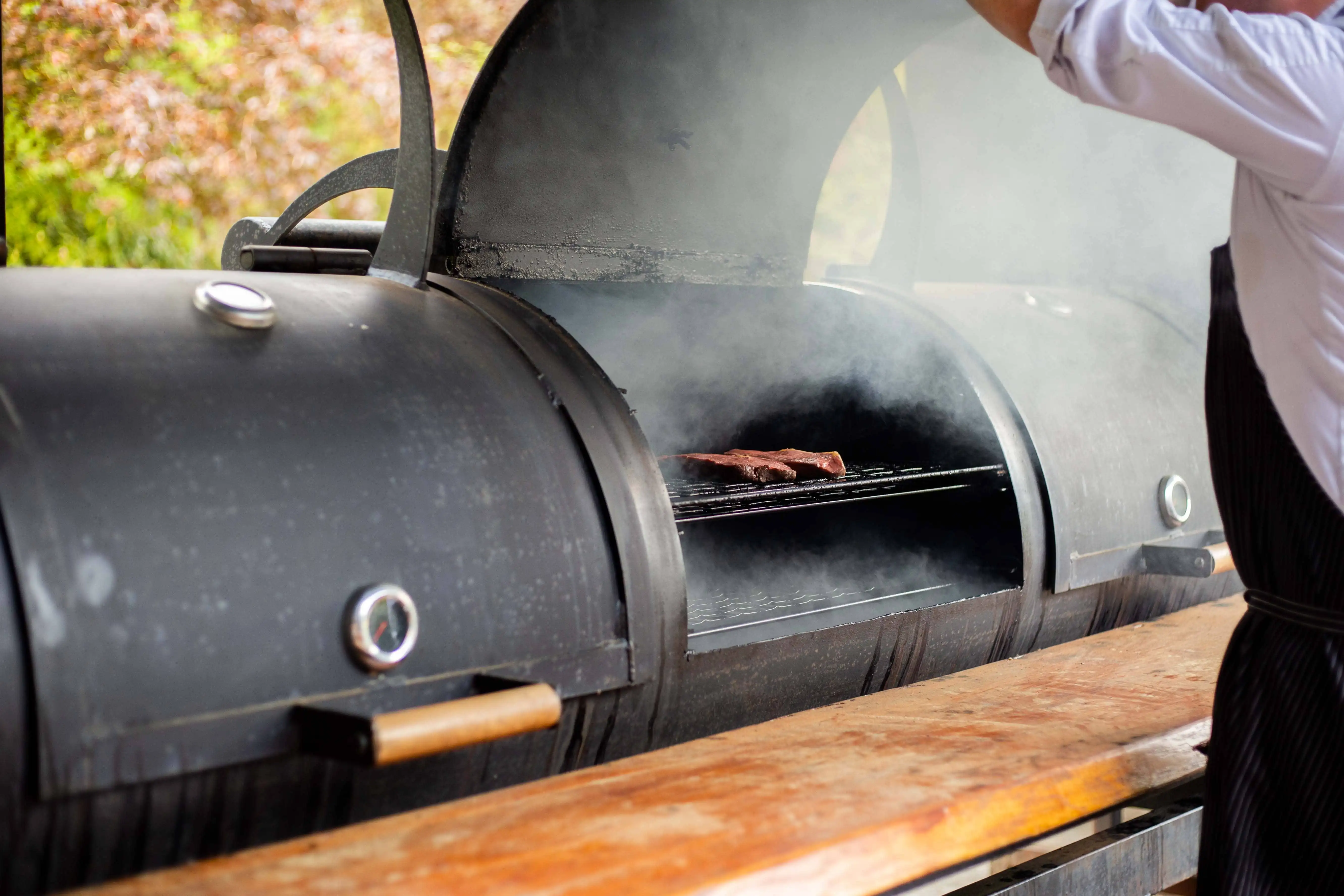 Barbecue staat open terwijl er vlees op gebakken wordt